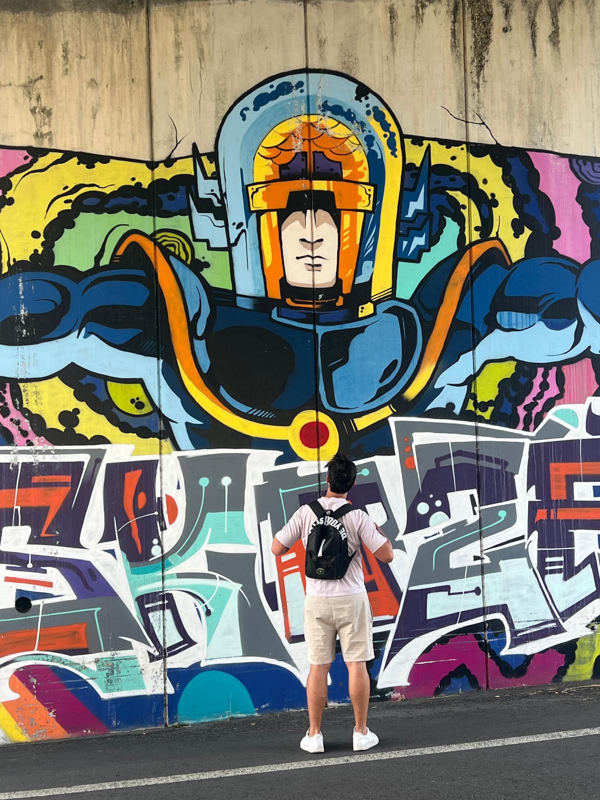 Persona con una mochila NORTEPACK frente a un mural de un astronauta